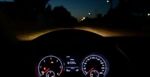 car headlights light up the road at night