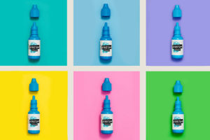 a sextet of eye drops upon different colored backgrounds