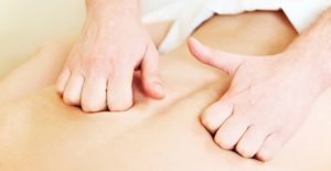 a massage therapist works on a client's back