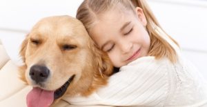 a girl hugs her dog after a flea and tick treatment