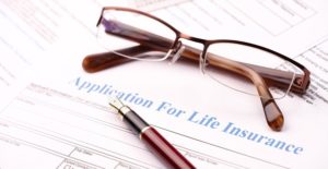 a pair of glasses sits on insurance paperwork