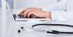 a man explores online medical assistant programs on his laptop