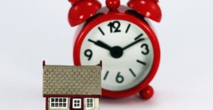a clock and a house symbolize that it's time to refinance your home mortgage