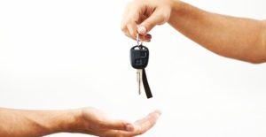 an individual hands over car keys after a car donation