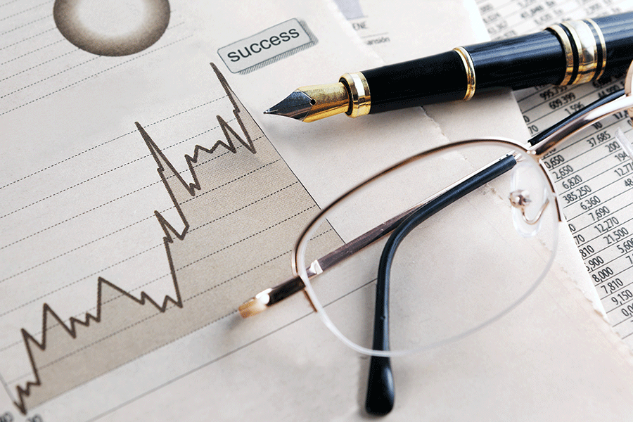a pen and glasses lying on top of a paper report of index funds and etfs