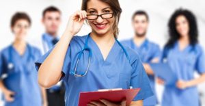 a nurse looks over here glasses while more nurses surround her in the background