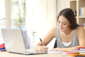 a young woman takes notes from a free online lsat prep course