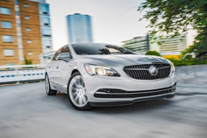 a silver buick lacrosse drives down the road