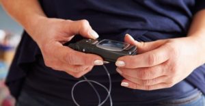 an individual tests blood sugar level with a monitor