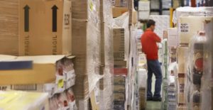 a warehouse worker uses inventory management software to log items