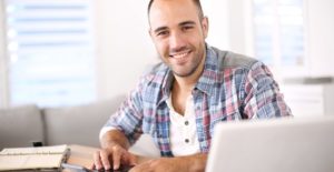 a man checks his online savings account on his laptop