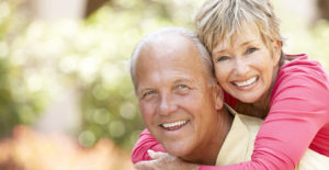 an older couple smiles and ponders a reverse mortgage