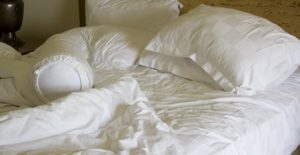 white bedding on a bed contaminated with bed bugs
