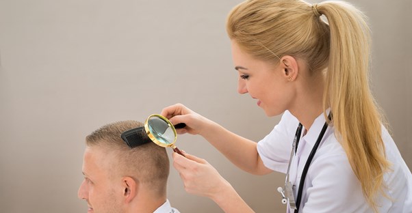 a female nurse checks for head lice in a man's hair