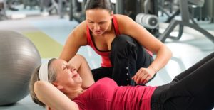 a female personal trainer helps a female client