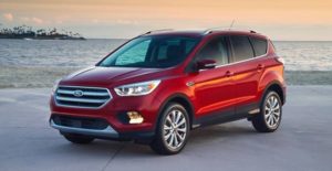 a red 2018 ford escape in front of the ocean