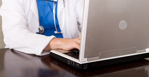 a medical professional explores healthcare management degrees online