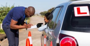 a driving instructor gives a new driver some driving test tips